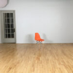 Blank wall with orange chair for scale